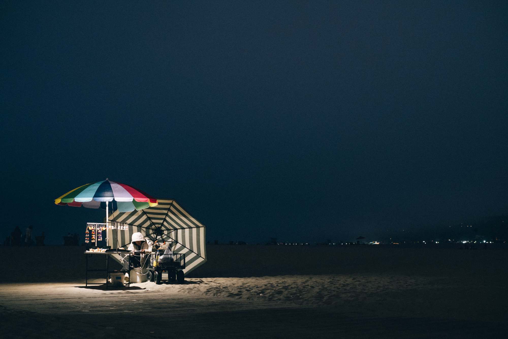 Pier Vendor Illuminated on a Dark Beach